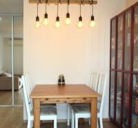 Dining area with a table and chairs, floor with wooden decor, 3-room apartment.