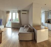 Spacious kitchen with living room in a 3-room apartment. Floor with wood decor, light furniture.