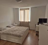 Bright bedroom in a 3-room apartment with a bed and wood-patterned flooring.