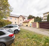 Parking lot near the offices on Bratislavská Street in Žilina, cars and garages in the background.