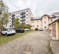 Parking lot and buildings on Bratislavská Street in Žilina, offices and residential buildings.
