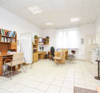 Offices with desks and chairs, white ceramic floor, shelves with books.