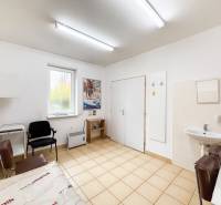 A doctor's office with a sink, chairs, and a window with a view, floor with a light decor.