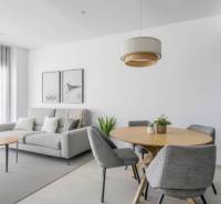Bright living room of the holiday apartment with a gray armchair and a wooden table.