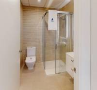 A bathroom in a holiday apartment with a toilet and a shower.