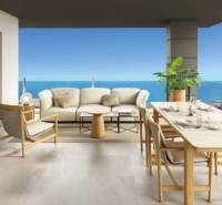 View from the spacious terrace of a holiday apartment in Torrevieja with furniture and the ocean.