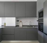 Kitchen in a holiday apartment with dark cabinets and built-in appliances.