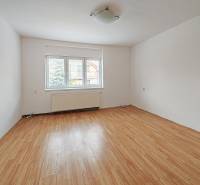 A room in a family house with a wooden decor floor and a large window.