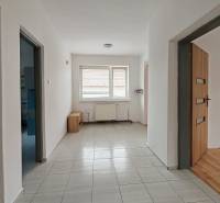Interior of a family house with tiling, wooden decor flooring, and a radiator.