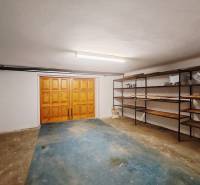 A garage in a family house with wooden doors and shelving units.
