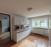 A kitchen in a family house with white cabinets and a floor with a wood decor.