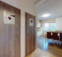 Entrance hall of a 2-room apartment with a wooden decor floor and a dining area.