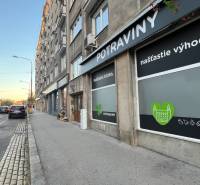 Krížna Street in Bratislava, next to the road there is a grocery store with advertising signs.