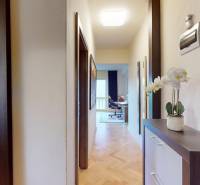 A hallway with entrances to the kitchen and a room in a two-room apartment, flooring with a wood decor.