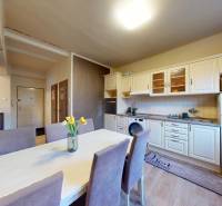 Kitchen and dining area in a 2-room apartment with a wooden decor floor.