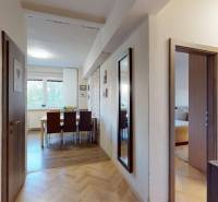 Hallway in a 2-room apartment with a wooden decor floor, living room with a dining table.