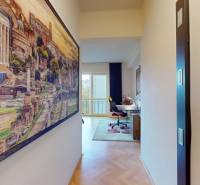 Hallway of a 2-room apartment with a decorative painting and a desk, floor with wooden decor.