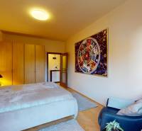 Bedroom in a 2-room apartment with a large bed, a picture on the wall, and a floor with a wood decor.