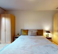 Bedroom in a 2-room apartment with a double bed, wardrobes, and a view of the balcony.