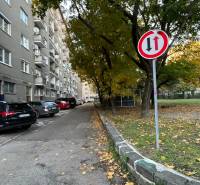 A street with residential buildings and cars in a parking lot in Bratislava on Krížna.