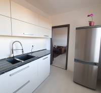 Kitchen in a 3-room apartment with a stainless steel refrigerator and a countertop, floor with wood decor.
