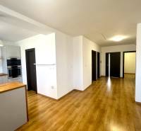 A kitchen in a family house with a wood-patterned floor and white walls.