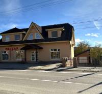 A family house in Bolešov with an attic, large windows, and a commercial space on the ground floor.