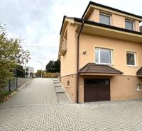 A family house in Bolešov with an access road and adjacent greenery in the autumn season.