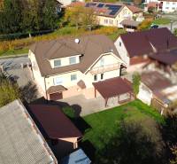A family house in Bolešov surrounded by greenery, with a courtyard and several outbuildings.