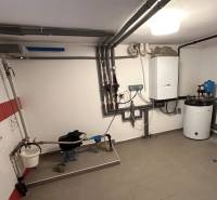 Technical room in a family house with a gas boiler and piping.