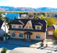 A family house in Bolešov with mountains in the background and a parking lot in front of the building.