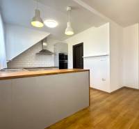 A kitchen in a family house with a wooden decor floor and white tiles.