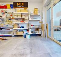 Commercial space with a wooden decor floor and shelves full of building materials.