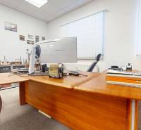 Office space with a wooden desk, computer, and decorative items on the walls.