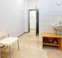 Commercial space with a sink, white wall, and wood-patterned flooring.