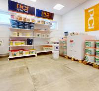 Commercial space with building materials, shelves with buckets, floor with wooden decor.