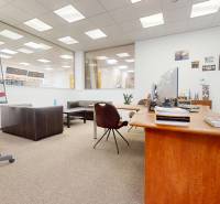 Commercial space with a wooden table, leather sofas, and a conference board.