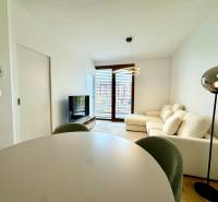 Living room in a two-room apartment with a comfortable sofa and a floor with a wooden decor.