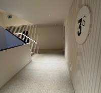 Hallway with floor designation, stairs, and safety signage.