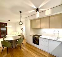 A kitchen in a 2-room apartment with a wooden decor floor and a dining table.