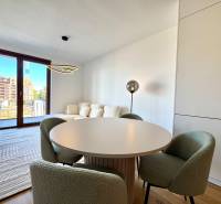 A two-room apartment with a wooden decor floor and a round dining table.