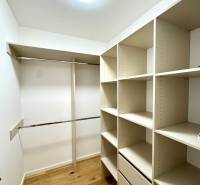 A wardrobe in a 2-room apartment with shelves and a floor with a wooden decor.