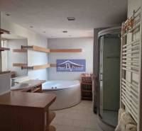 Bathroom in a 2-room apartment, with a bathtub, shower corner, and shelves.