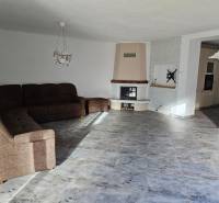 Living room in a family house with a wooden decor floor and a corner sofa.