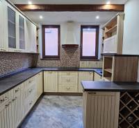 A kitchen with a tiled floor and wooden decor in a family house.