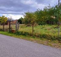 Residential plots in Gajary with visible fencing and surrounding trees offer tranquility.