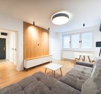 Living room with a sofa, dining table, wooden floor decor in a two-room apartment.