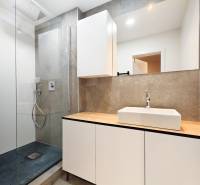 Bathroom in a 2-room apartment with a modern shower and a large mirror.
