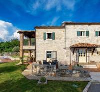 Stone villa in Bale with a pool and terrace surrounded by greenery.
