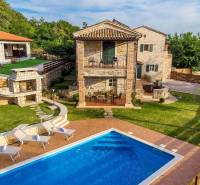 Villa in Bale with a garden, swimming pool, sun loungers, and a stone fireplace.